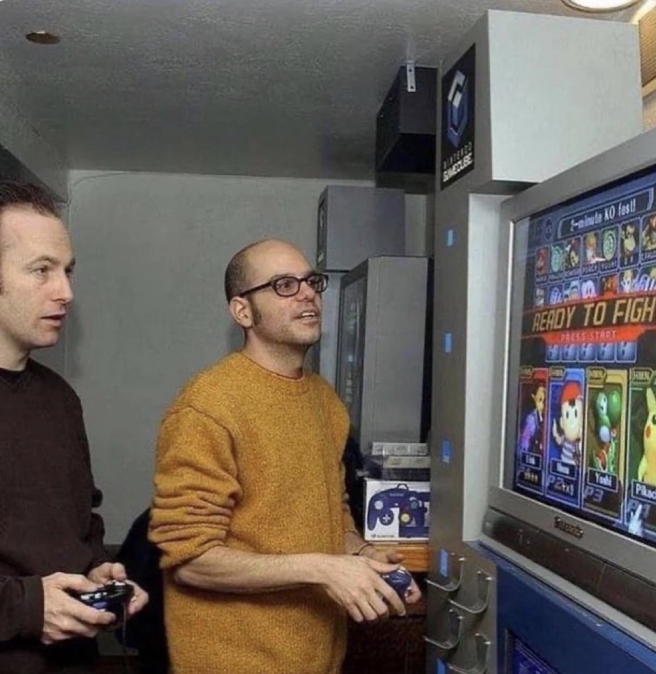 Two people playing a video game at a GameCube kiosk